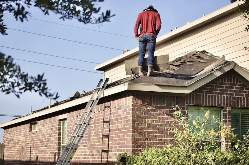 Professional roofer working on a residential roof in Northeast Millair